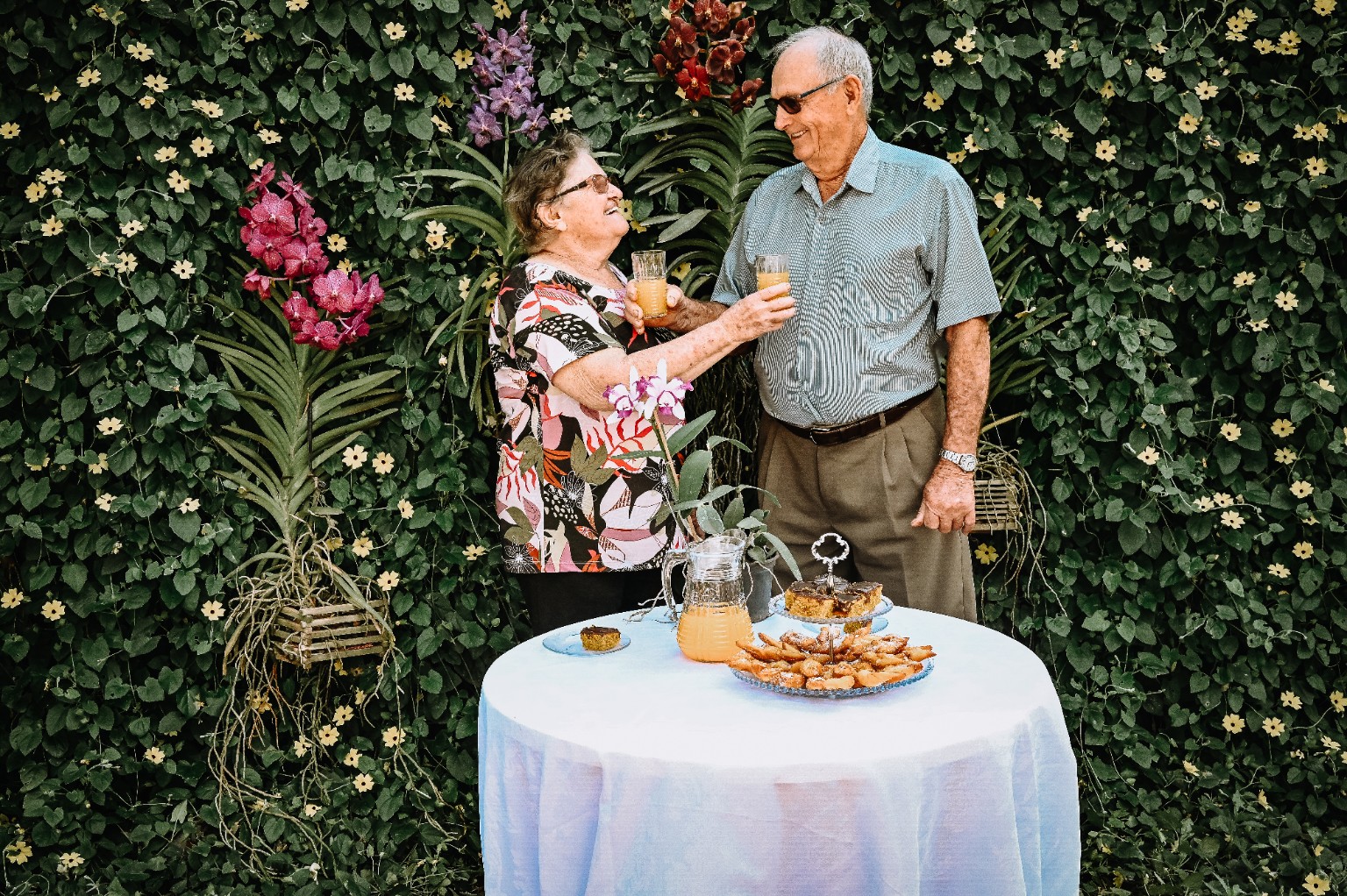 Casal brindando em meio ao jardim do Orquidário Quinze